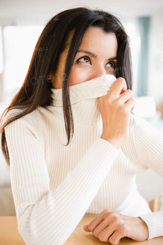 Portrait of woman covering face with turtle neck. Photo : Jamie Grill
