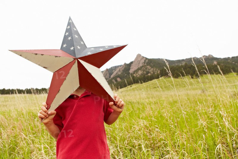 Boy (6-7) playing with star with American flag pattern. Photo: Shawn O'Connor