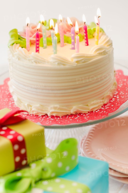 Studio shot of colorful birthday cake and birthday gifts.