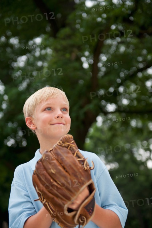 Boy (10-11) wearing baseball glove.