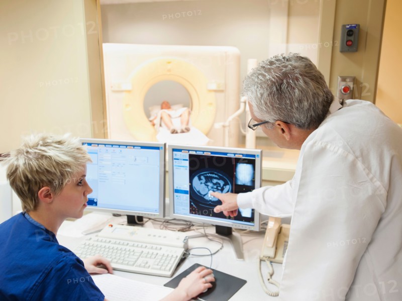 Doctor and nurse looking at CAT scan of patient's brain. Photo: Erik Isakson