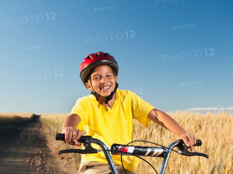 Boy (8-9) cycling along dirt road. Photo: Erik Isakson