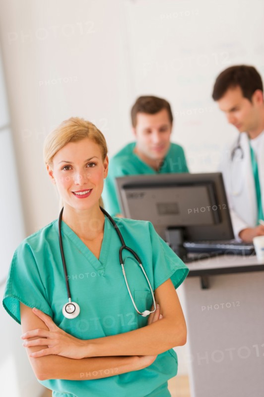 Portrait of female doctor in front of nurse's station.