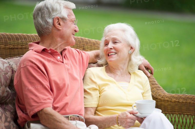 Senior couple relaxing on outdoor sofa.