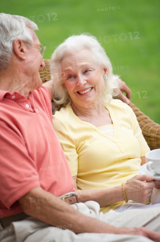Senior couple relaxing on outdoor sofa.