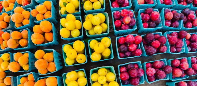 Market stall with colorful fruits in cartons.