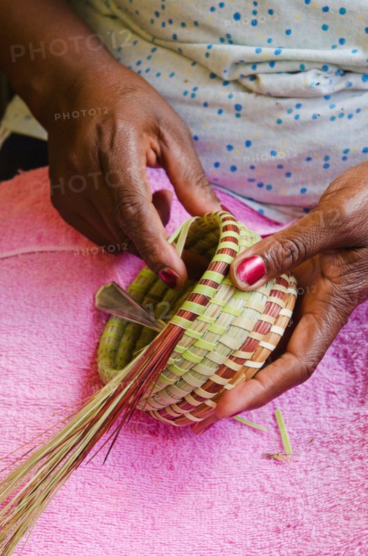 USA, South Carolina, Charleston, Close up of woman's hand weaving sweetgrass basket.