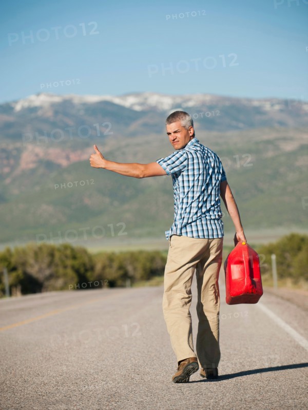 USA, Utah, Kanosh, Mid adult man carrying empty canister attempting to stop vehicles for help. Photo: Erik Isakson