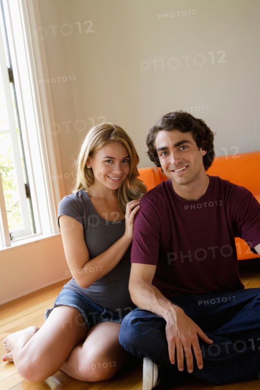 Portrait of young couple in living room. Photo : Rob Lewine