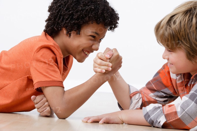 Studio shot of two boys (8-9) arm-wrestling. Photo: Rob Lewine