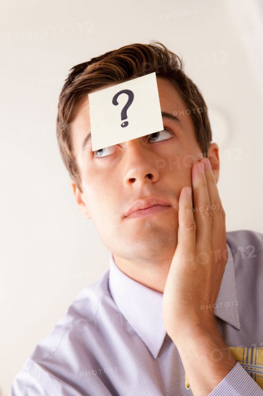 Portrait of businessman with adhesive note attached on forehead. Photo: Rob Lewine