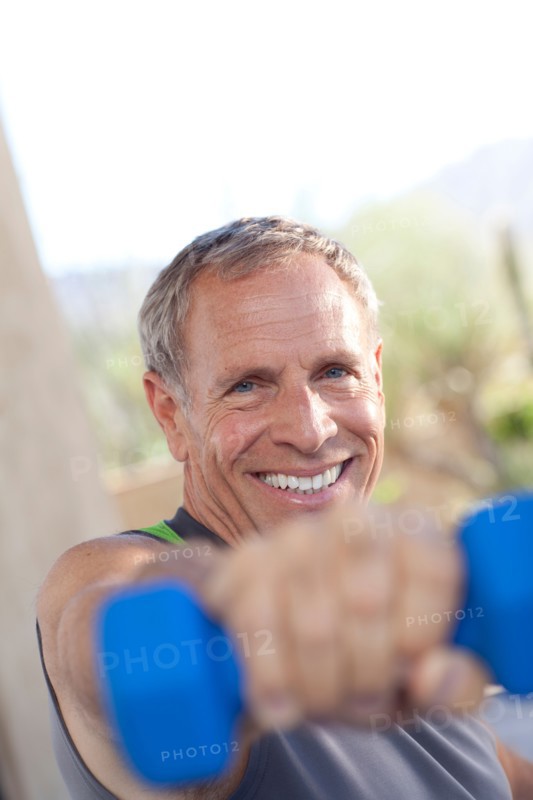 Portrait of senior man lifting dumbbells. Photo : db2stock