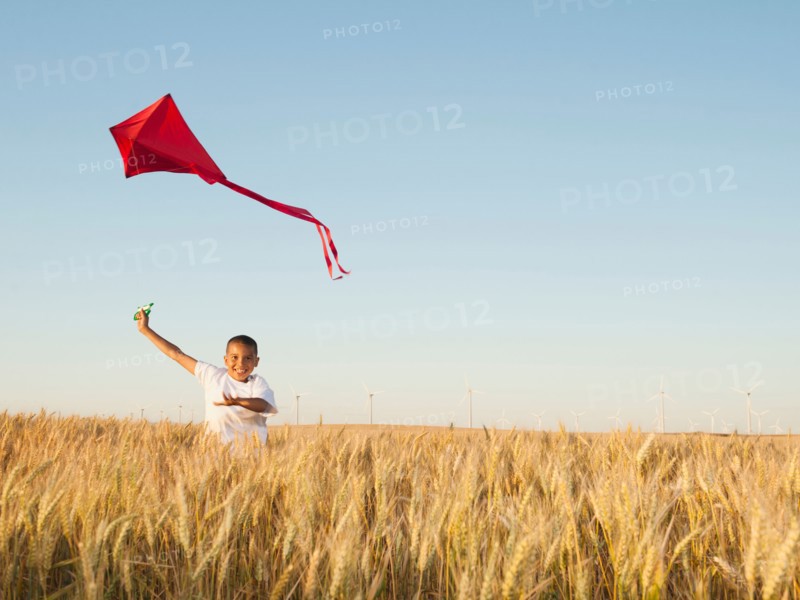 Boy (10-11) playing with kite in wheat field. Photo: Erik Isakson