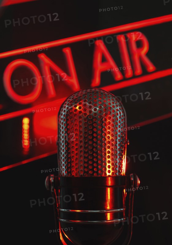 Vintage microphone and red on air neon, studio shot.