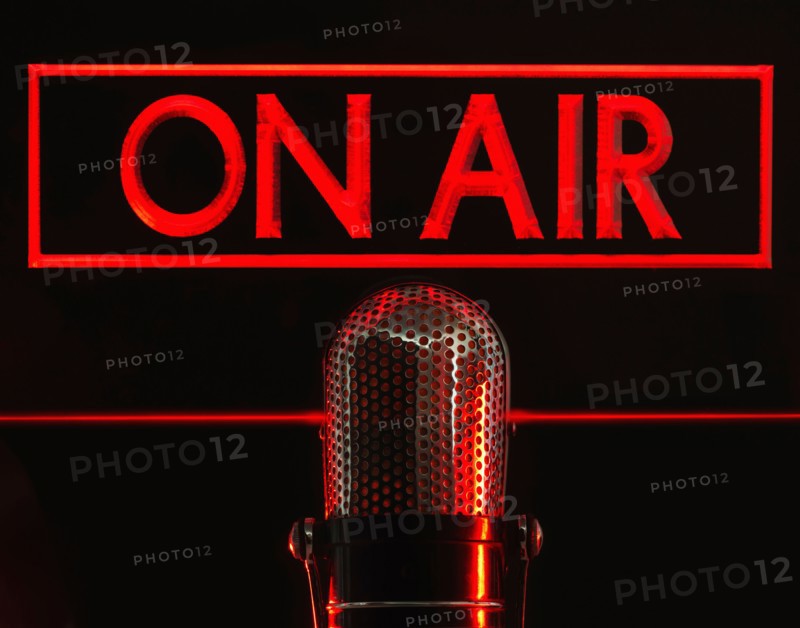 Vintage microphone and red on air neon, studio shot.