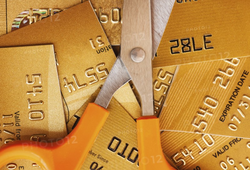 Scissors on pile of credit cards, studio shot.
