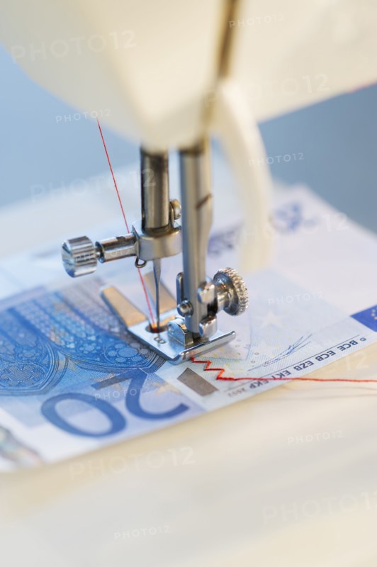 Sewing machine stitching 20 euro note, studio shot.