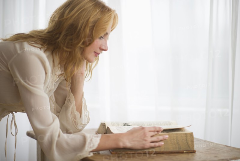 Woman reading antique book.