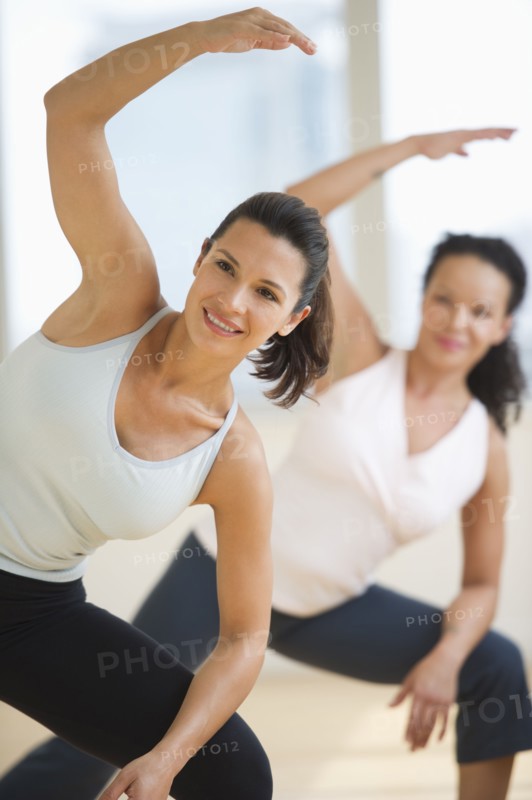 Two women exercising in gym.