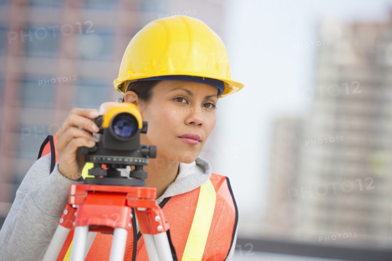 Surveyor using a theodolite instrument.