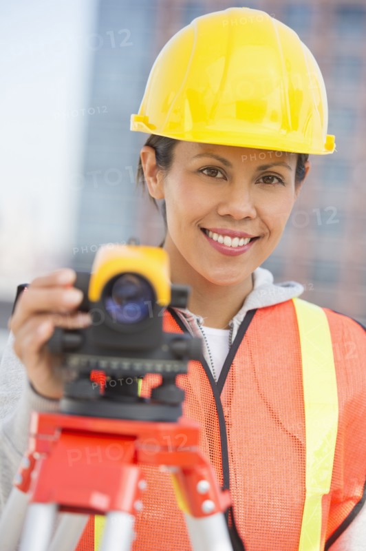 Surveyor using a theodolite instrument.