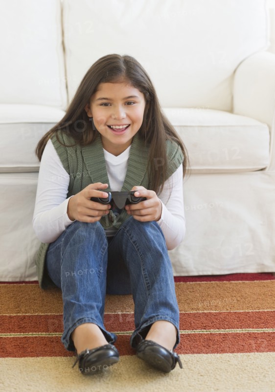 Girl (10-11) playing video games.