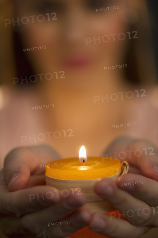 Woman holding tealight.