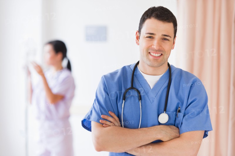Portrait of doctor, nurse in background.