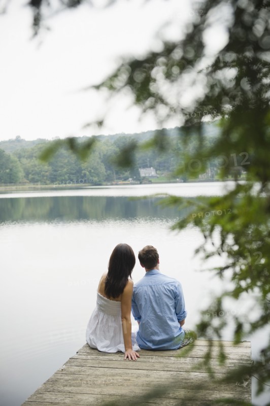 USA, New York, Putnam Valley, Roaring Brook Lake, Couple sitting on pier by lake. Photo : Jamie Grill