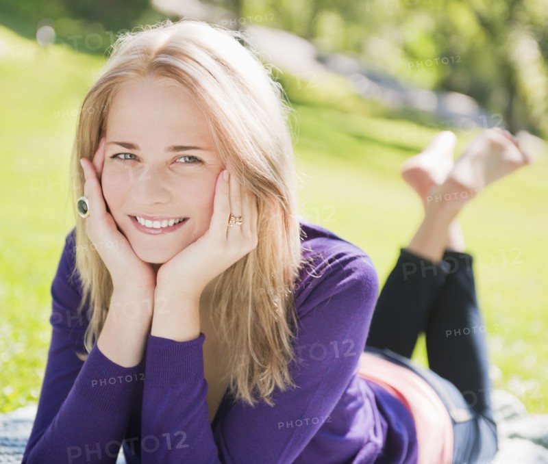 USA, New York, New York City, Manhattan, Central Park, Young woman lying on grass. Photo : Daniel Grill