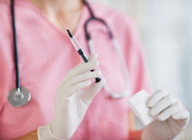 Close up of hands of female nurse holding syringe and gaze. Photo: Daniel Grill