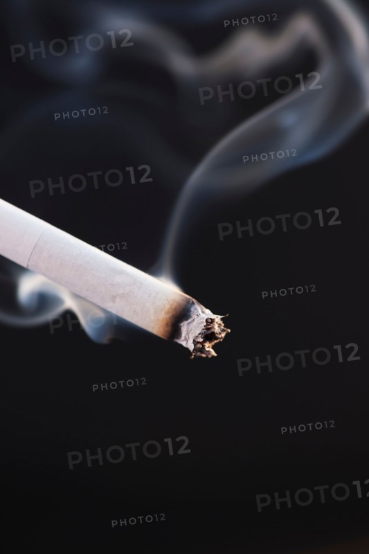 Close up of burning cigarette on black background. Photo: Daniel Grill