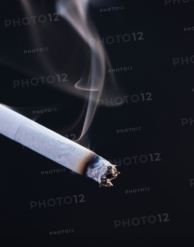 Close up of burning cigarette on black background. Photo: Daniel Grill