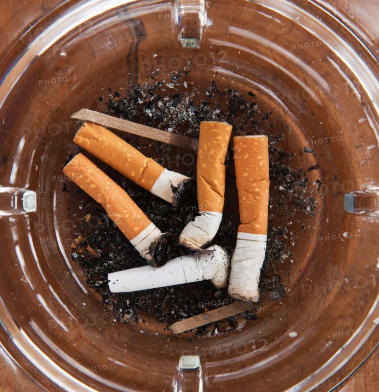 Close up of cigarette butts in glass ashtray. Photo: Daniel Grill