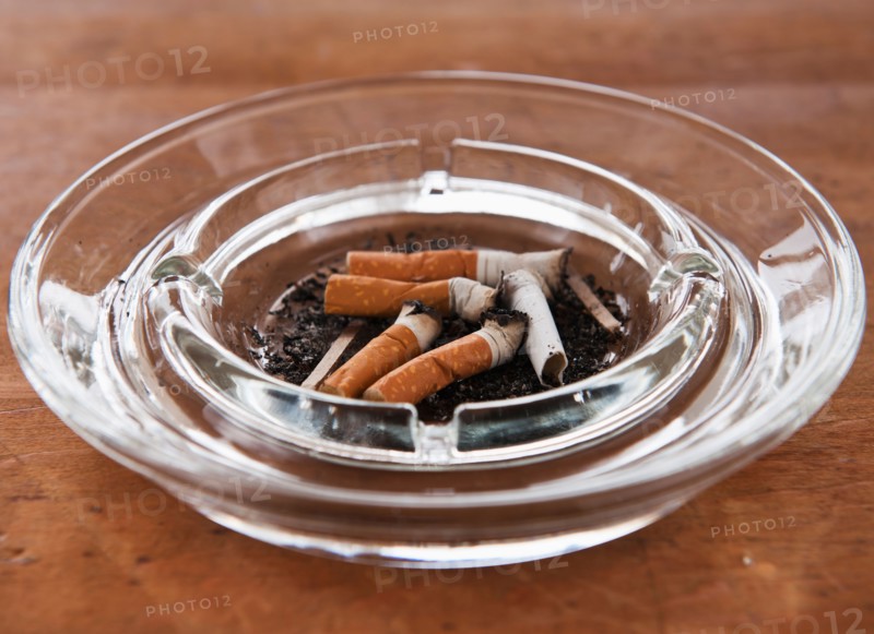 Close up of cigarette butts in glass ashtray. Photo: Daniel Grill
