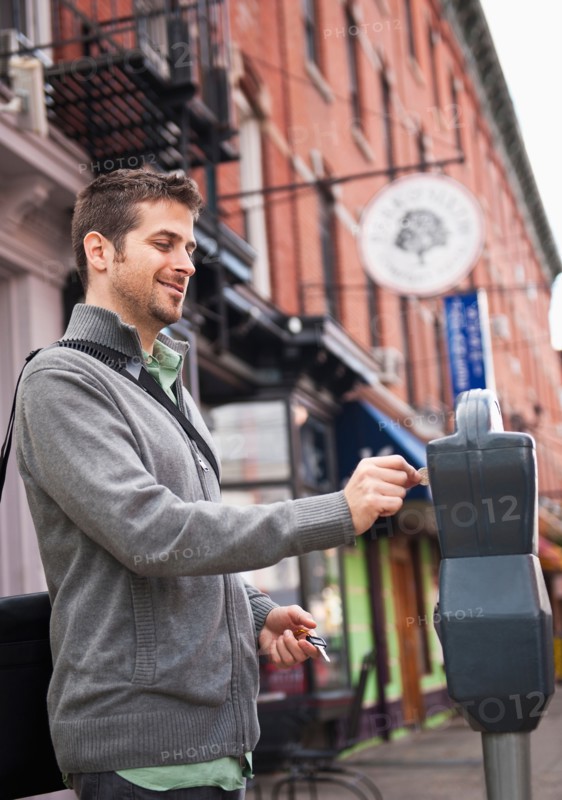 Man inserting coin to parking meter. Photo: Daniel Grill