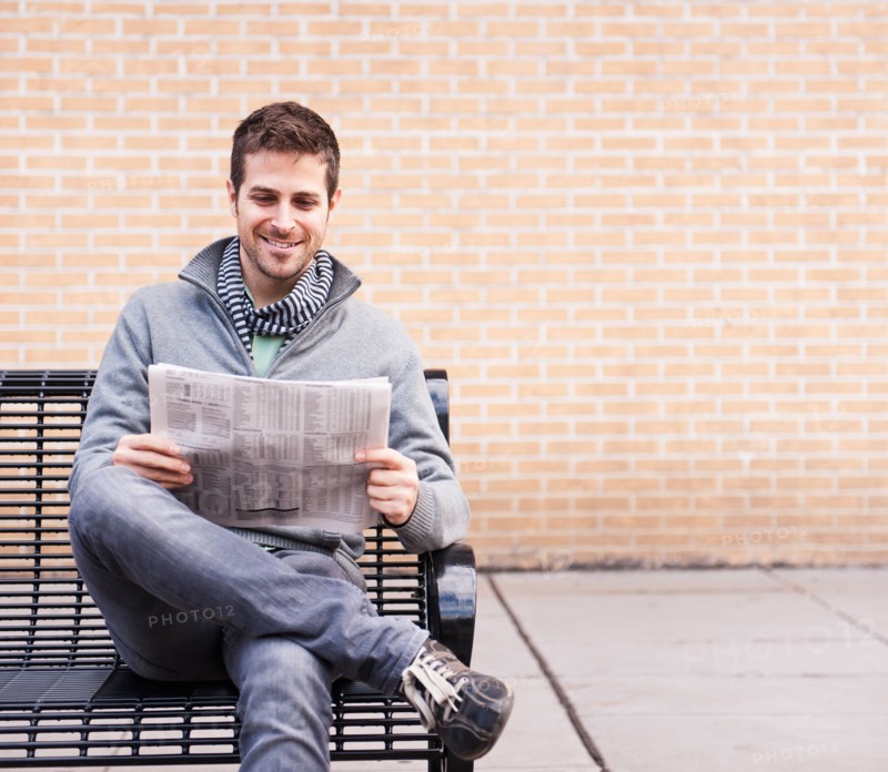 Man on bench reading newspaper. Photo : Daniel Grill