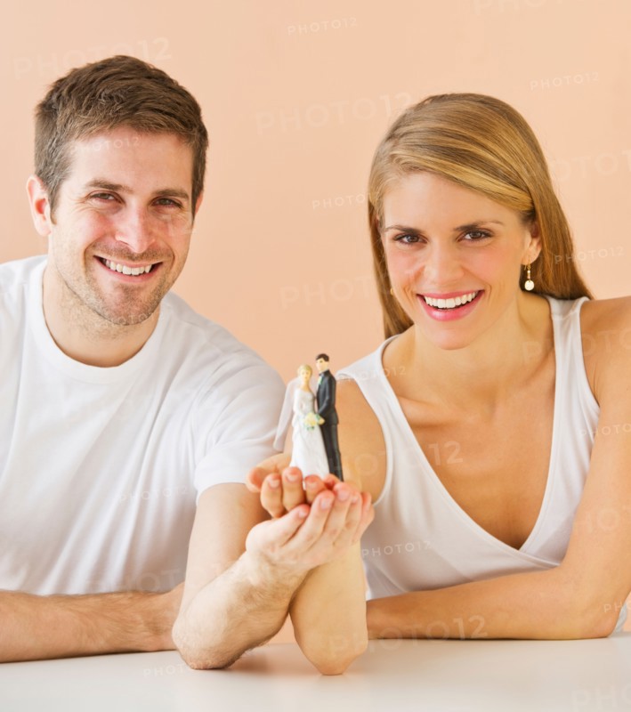 Couple holding small wedding figurine. Photo: Daniel Grill