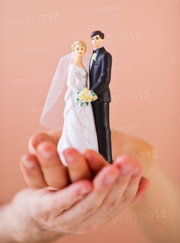 Couple holding small wedding figurine. Photo: Daniel Grill