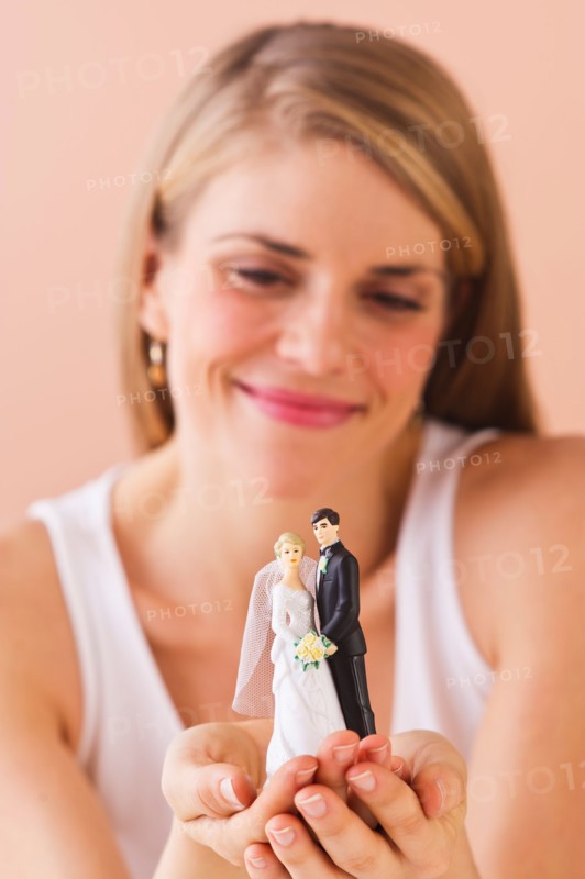 Young woman holding wedding figurine. Photo : Daniel Grill