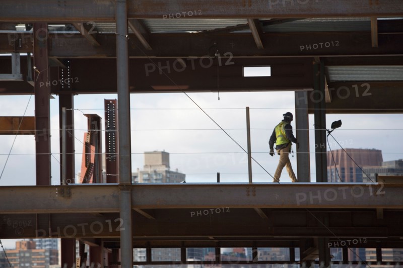 USA, New York City, Construction worker walking inside of unfinished structure. Photo : fotog