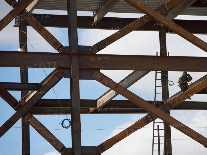 Construction worker working on unfinished structure. Photo : fotog