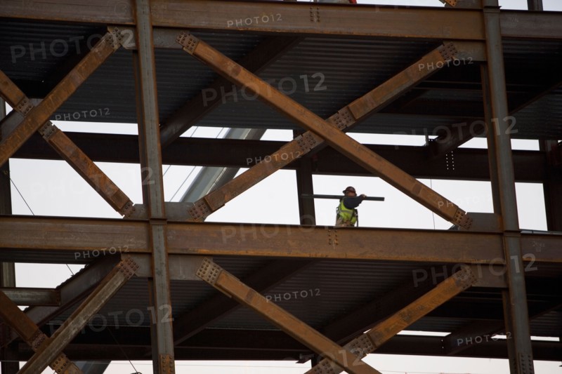 Construction worker working on unfinished structure. Photo : fotog