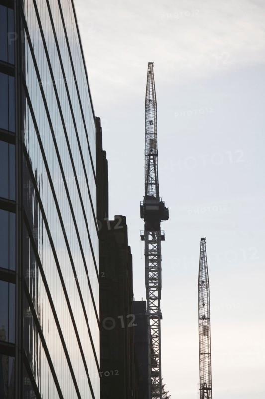 USA, New York City, Modern office building and cranes in background. Photo : fotog