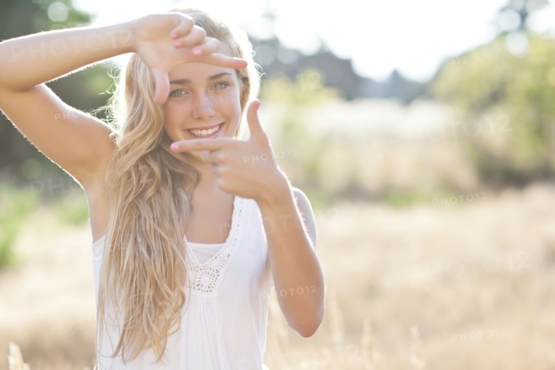 Teenage girl (16-17) displaying finger frame. Photo: Take A Pix Media