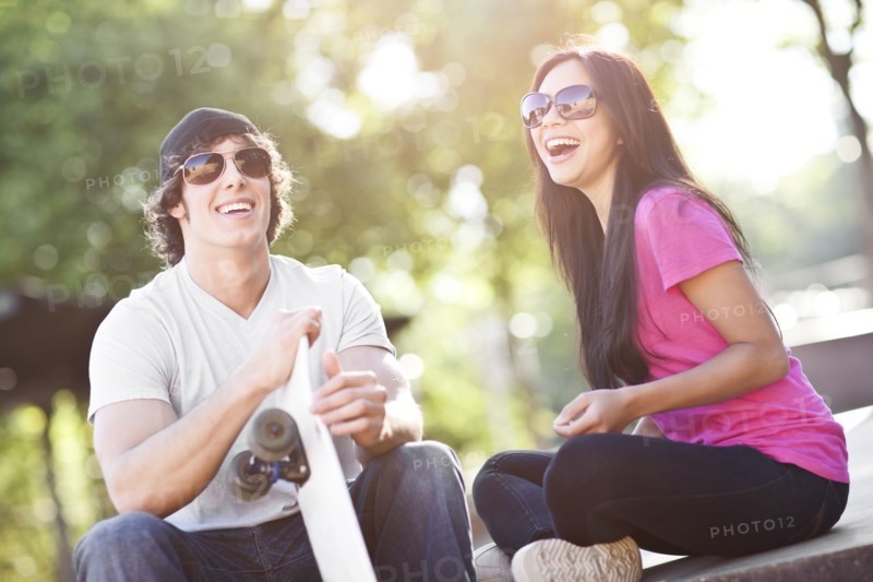 Young multi-racial couple posing with skateboard. Photo: Take A Pix Media
