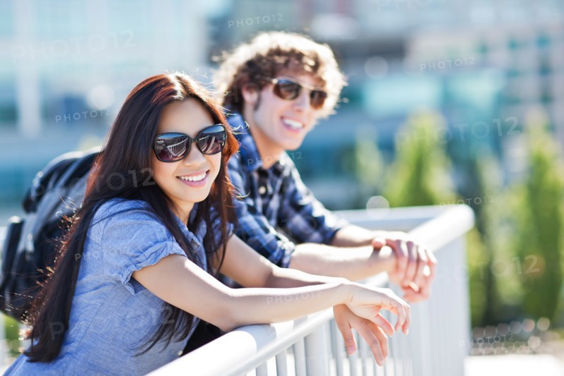 Couple standing by banister outdoors. Photo : Take A Pix Media