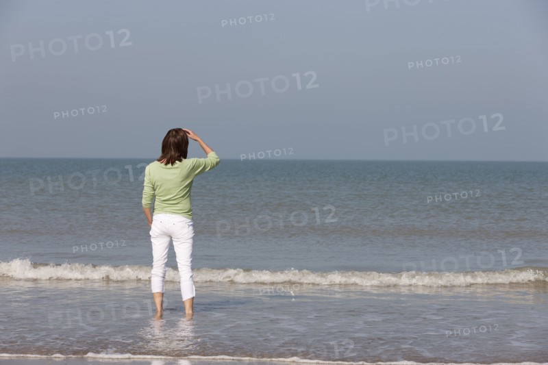 Woman on beach looking out to sea. Photo : Jan Scherders