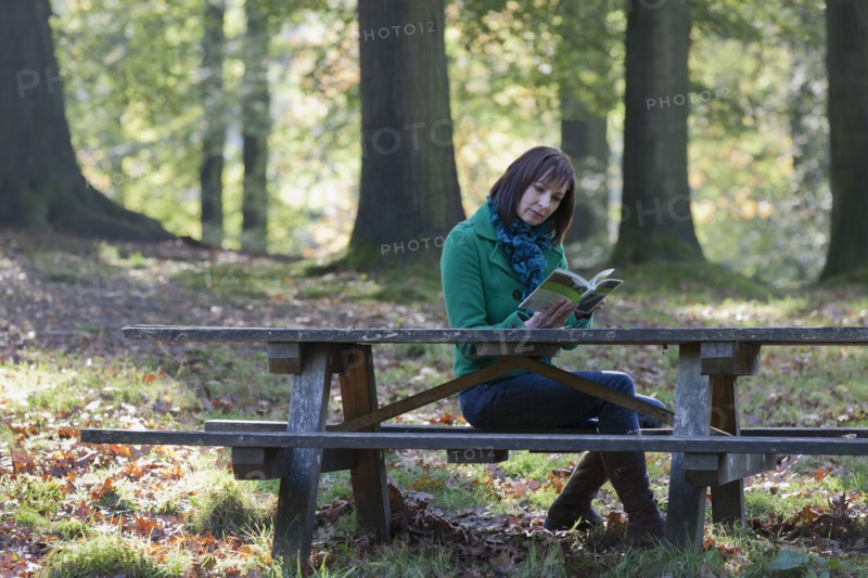 The Netherlands, Veluwezoom, Posbank, Woman reading book in park. Photo : Jan Scherders
