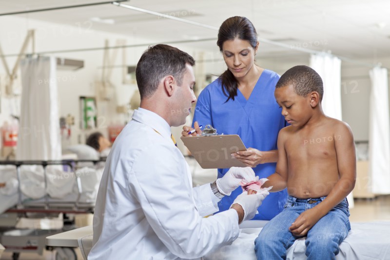 Doctors applying bandage on boy's (4-5) hand. Photo: db2stock